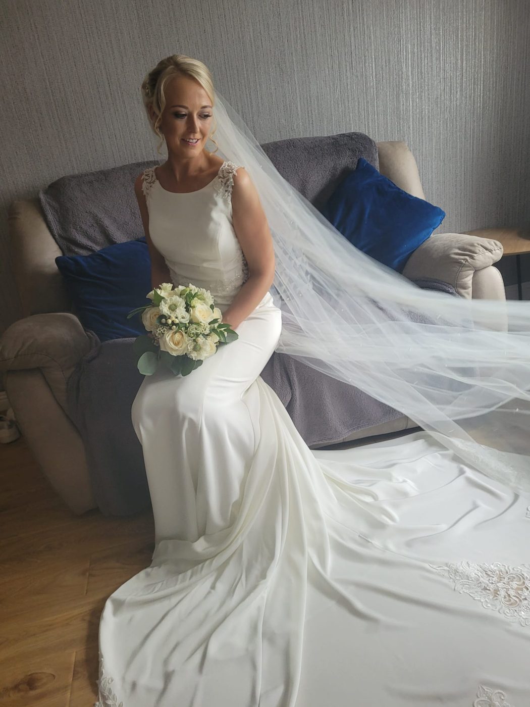 Bride with a sleek style and full-length veil before the ceremony, styled at INCH Hair Design